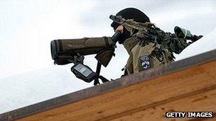 Armed policeman standing guard on the roof of the conference centre