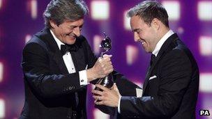 Alan Halsall picks up the best serial drama performance award from Coronation Street co-star Nigel Havers