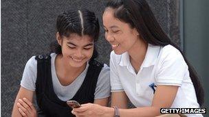 Women in Thailand use a mobile phone