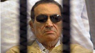 Ousted Egyptian president Hosni Mubarak sits inside a cage in a courtroom in Cairo on 2 June, 2012. This year the verdict in his former trial was overturned and a retrial ordered.