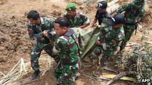 Indonesian soldiers evacuate a dead body, the victim of a recent landslide that hit Nagari Sungai Batang village in Agam