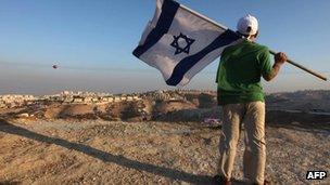 Israeli boy holds his national flag during a protest near the Jewish settlement of Maale Adumim, east of Jerusalem, in 2009