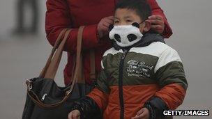 A boy wears a mask on Beijing's Tiananmen Square