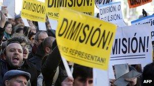 People brandish envelopes and placards reading "Resignation!" outside the Popular Party headquarters in Madrid on 2 February.