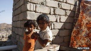 Two little girls stand outside their family's hut in the mountainous village of al-Ma'jalah, in the southern Yemeni province of Abyan