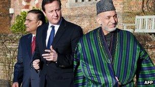 Britain's Prime Minister David Cameron (C) walks with Afghan President Hamid Karzai (R) and Pakistani President Asif Ali Zardari (L) at the British prime minister's official residence, Chequers (4 Feb 2013)