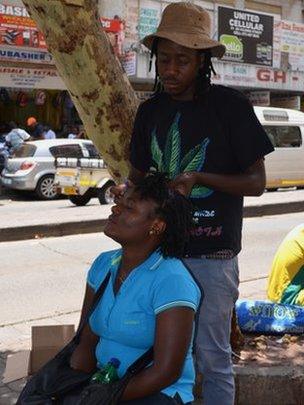 Andile Khumalo tends to a client's hair