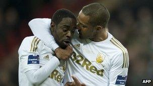 Swansea City"s English midfielder Nathan Dyer (L) and Swansea City"s English midfielder Wayne Routledge (R) talk after Dyer loses out on taking the penalty during the League Cup final football