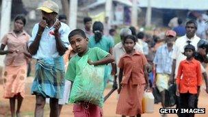 Internally displaced Tamils leave their camp with belongings in the northern town of Vavuniya (23 December 2009)