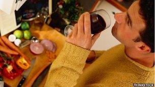 Man drinks wine while cooking