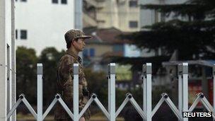 A Chinese People's Liberation Army soldier stands guard in front of "Unit 61398", a secretive Chinese military unit, in the outskirts of Shanghai, February 19, 2013