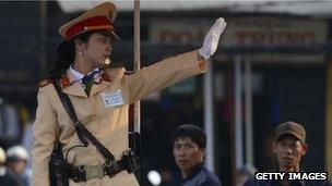 A Vietnamese police woman directs traffic in Hanoi