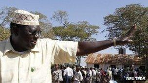 Malik Obama, half-brother of U.S. President Barack Obama, waves to voters as they queue at a polling centre after casting his ballot, while contesting for the governorship of the rural Siaya county as an independent candidate in their ancestral home village of Nyangoma Kogelo, 430 km (367 miles) west of Kenya"s capital Nairobi, March 4, 2013
