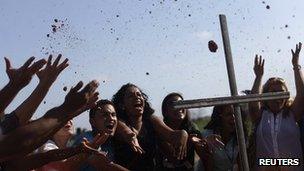 People throw blessed soil after a blessing ceremony at the farm Vila Mar site, where the new Pope is expected to celebrate mass during World Youth Day