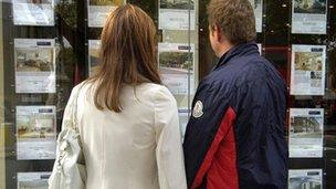 Couple looking in estate agent window