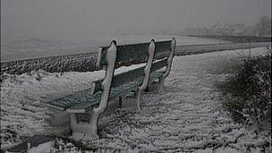 Bench in snow along Guernsey's east coast