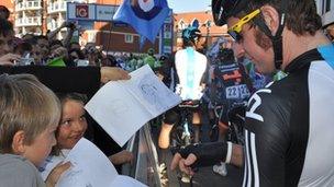 Bradley Wiggins signs a drawing of him for two fans in Ipswich