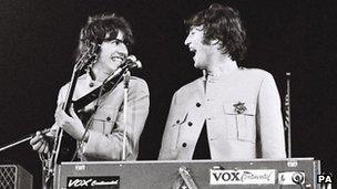 George Harrison [left] and John Lennon during The Beatles Shea Stadium performance in August 1965 in New York