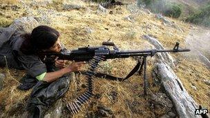 A female member of the PKK practises firing her rifle