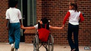 Physically handicapped child holds hands with friends