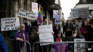 Protesters against government cuts gather outside Canterbury Cathedral.