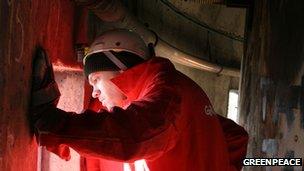 Greenpeace activist Ben Stewart looking out from inside a tower