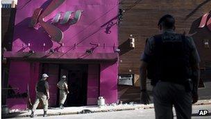 Police officers search the premises of the Kiss nightclub in January 2013