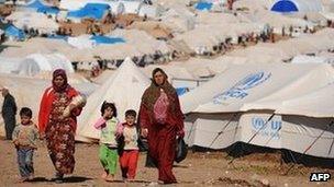 Syrian internally displaced people walk in the Atme camp, along the Turkish border