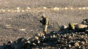 Paratrooper from French Foreign Legion standing up on a rocky hill on the valley of Therz