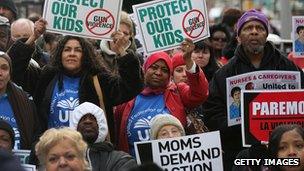 Protesters hold up gun control signs