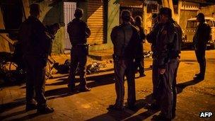 Police inspect the bodies of two men killed in the streets of Sao Paulo last week