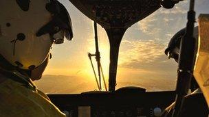 Pilots look out at setting sun while in flight