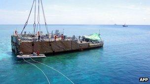 This undated handout photo released on 30 March 2013 shows the stern of the USS Guardian before being lifted by a boat crane at Tubbataha reef, in Palawan Island, Philippines