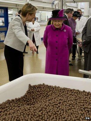 The Queen and Fiona Dawson (left), President of Mars Chocolate UK, look at a vat containing Maltesers