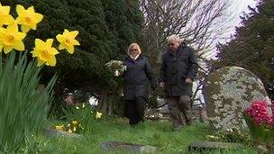 Sue and Peter cook lay flowers for her relatives at St Andrew's church in Congresbury