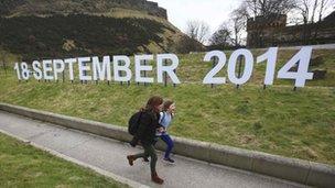 Children running alongside sign showing referendum date