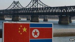 A sign displaying the Chinese (L) and North Korean (R) flags is pictured beside the Sino-Korean Friendship Bridge which leads to the North Korean town of Sinuiju, on the banks of the Yalu River, in Dandong on February 7, 2013.