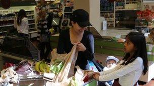 Nayeli Gonzalez packs her groceries with her children