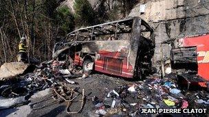 Firefighter stands near bus wreckage