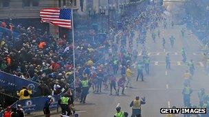 Wide shot of Boston Marathon finish as bomb goes off