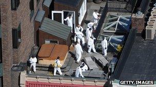 Investigators search the roof of a building on the marathon route