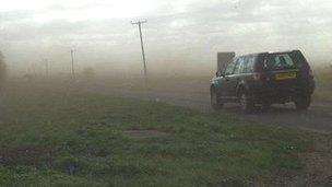 Mud blown across a road in Cambridgeshire