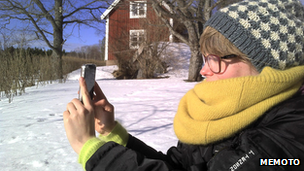 Lady taking a photo using a phone, photographed by Memoto