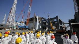 Journalists inspect damaged No.4 reactor building at Fukushima Daiichi nuclear power plant