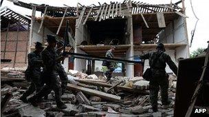 Chinese soldiers remove a bed from the rubble of a destroyed home as they help local residents in Longmen village after a magnitude 7.0 earthquake hit Lushan, Sichuan Province on 22 April 2013