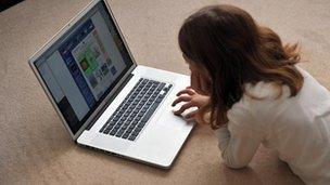 Girl browsing the internet on a laptop computer at home