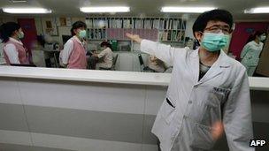 A nurse (R) introduces the front desk for the negative pressure isolation rooms section, which will be used to treat potential H7N9 avian influenza patients, at Taipei Hoping Hospital, 6 April 2013