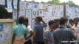 Relatives paste missing notices to a wall near the collapsed building