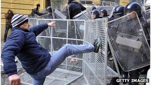 A man kicks at a policeman in Zagreb during demonstrations over high unemployment in Croatia