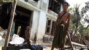 Ko Ko Naing, a Muslim man, stands in front of his home, damaged by Buddhist mobs the previous day, in Kyaw Boi Lay village on 1 May 2013